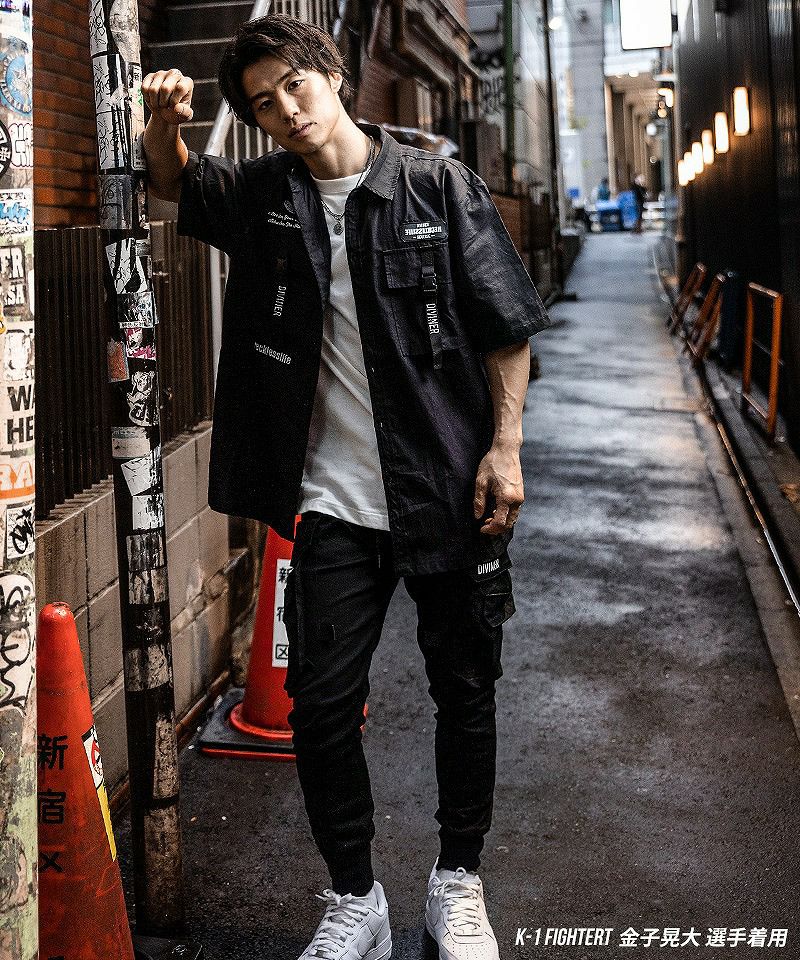 黒シャツとカーゴパンツを合わせた韓国ストリートコーデでカルマヘアの男